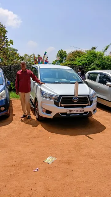 Carzon Rentals driver with a white Innova Crysta in Chennai