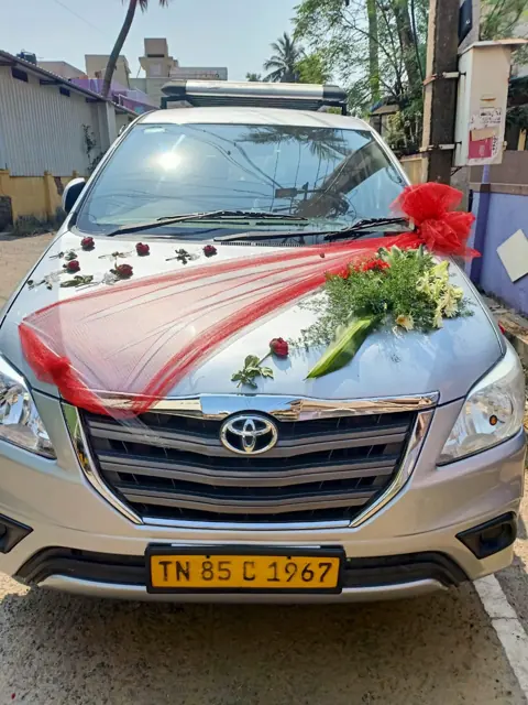 Toyota Innova decorated with ribbons and roses for a Chennai wedding